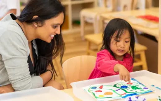 a person and a child looking at a book