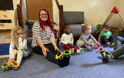 a person and several children sitting on the floor
