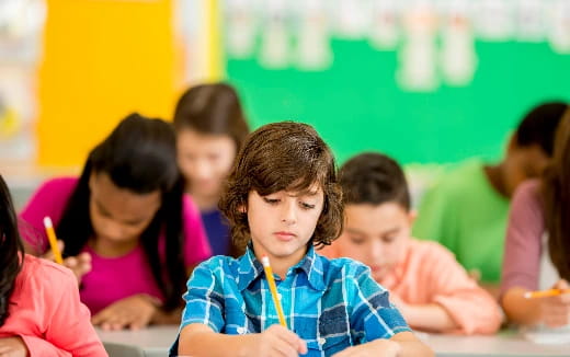 a group of children sitting at desks in a classroom