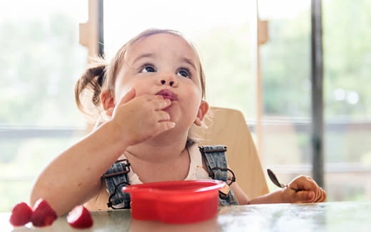 a baby eating from a bowl