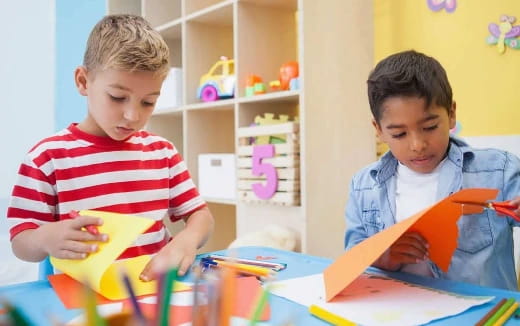 a couple of boys looking at a book