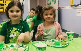 a group of children sitting at a table eating food