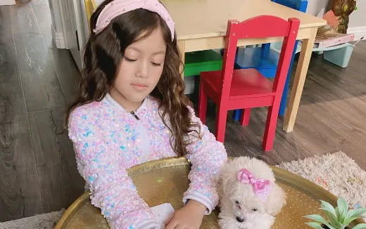 a girl sitting on the floor with a dog