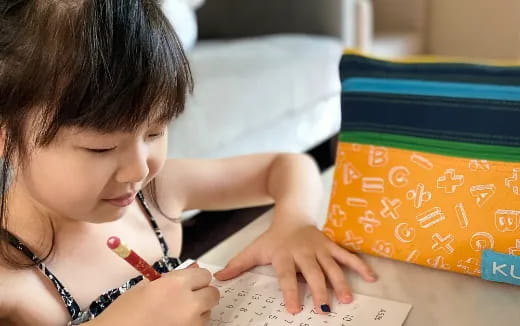a young girl writing on a book