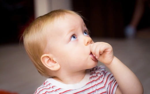 a baby with a hand on its face
