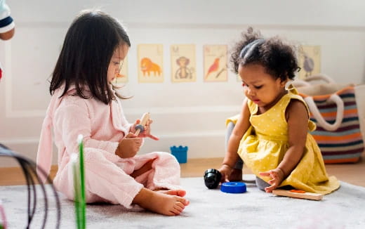 a couple of young girls sitting on the floor