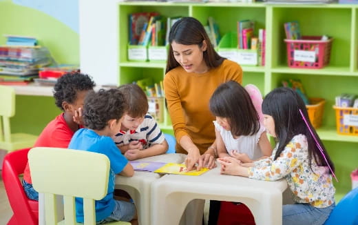 a person and several children sitting at a table