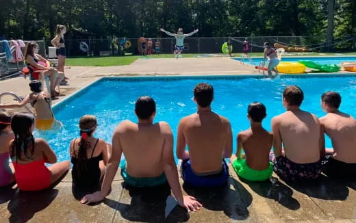 a group of people sitting around a pool