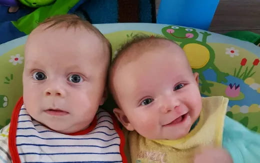 two babies lying on a blanket