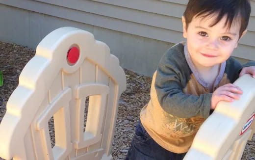 a boy holding a white cylinder