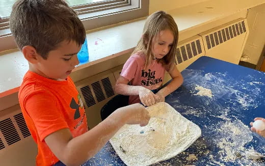 a boy and girl playing in a pool
