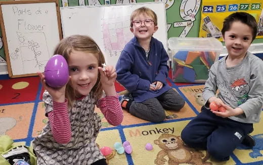 a group of children sitting on the floor with toys