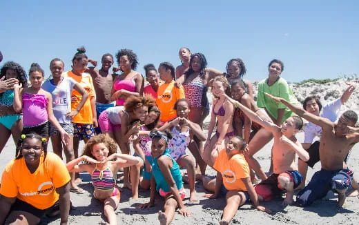 a group of people posing for a photo on a beach