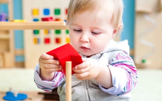 a baby holding a red phone