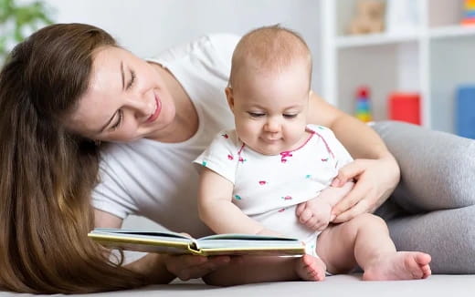 a person reading a book to a baby