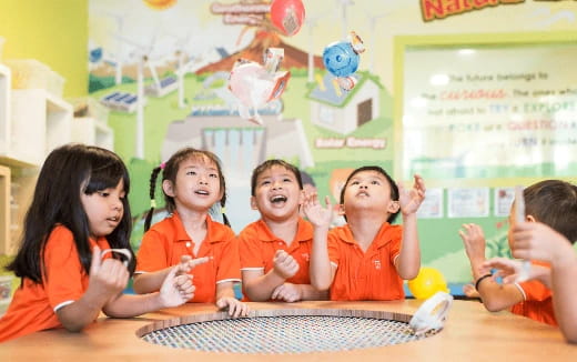 a group of children in orange shirts