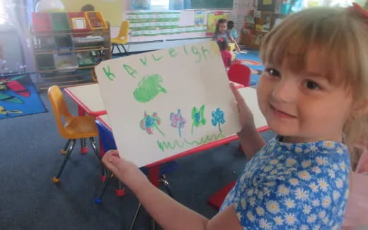 a child holding a drawing