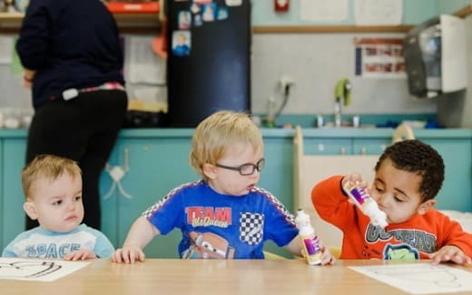 a group of boys sitting at a table with a toothbrush