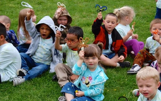 a group of children sitting on the grass