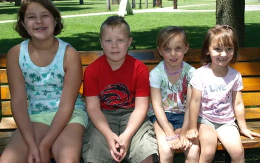 a group of children sitting on a bench