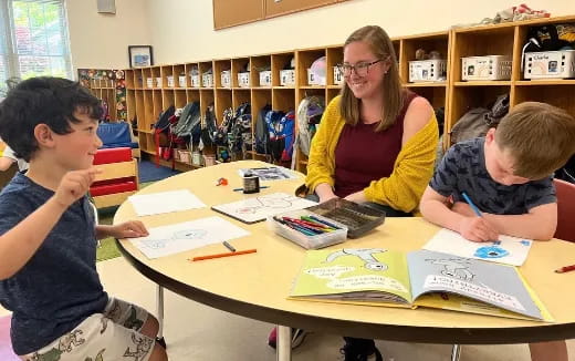 a person and several children sitting at a table