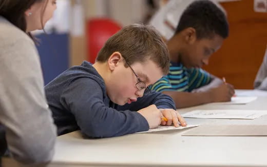 a boy writing on a piece of paper