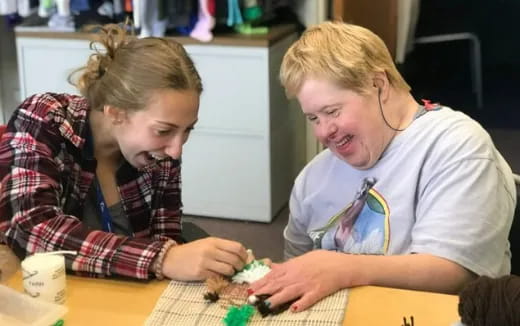 a man and a woman looking at a small toy