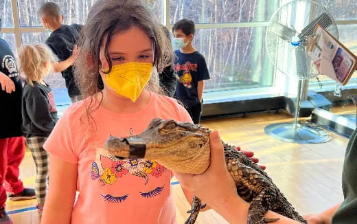 a girl holding a lizard