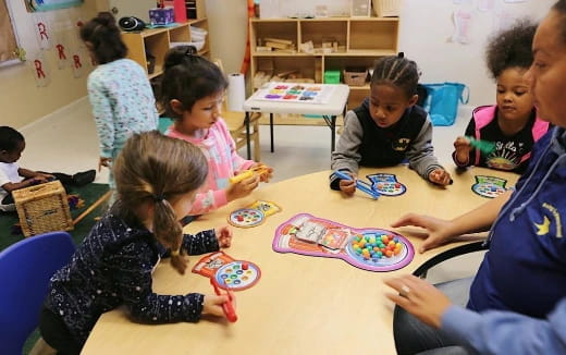 a group of children sitting around a table