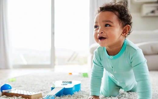 a baby standing on a carpet