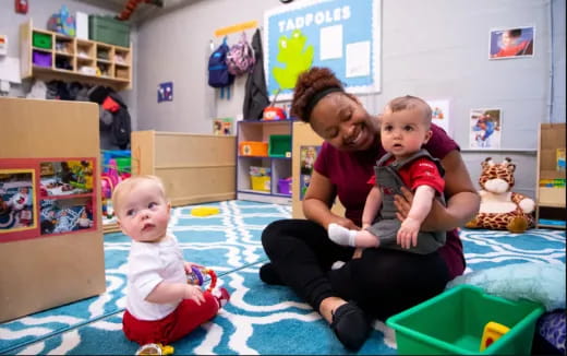 a person and two children sitting on the floor