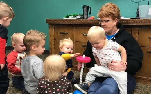 a person feeding a group of children