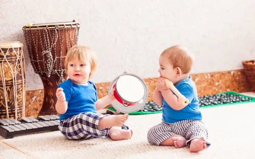two babies sitting on the floor