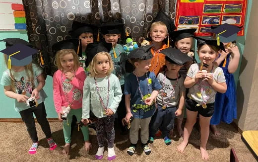 a group of children wearing graduation hats