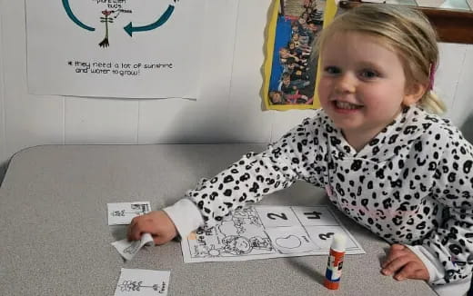 a young girl sitting at a table