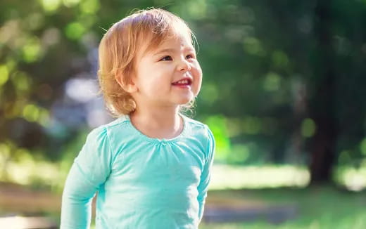 a child smiling outside