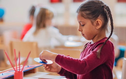 a young girl writing on a piece of paper