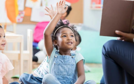 a young girl raising her hands