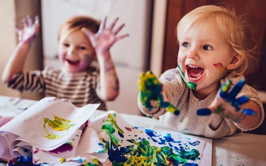 a couple of kids sitting at a table with a cake