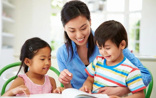 a person and children looking at a book