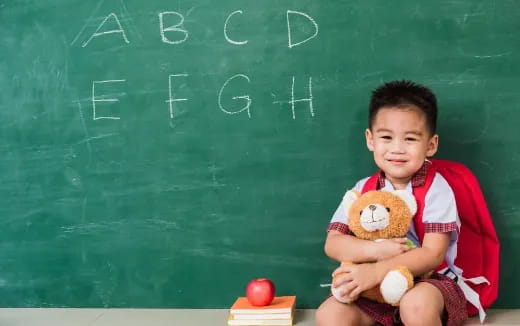 a young boy holding a teddy bear