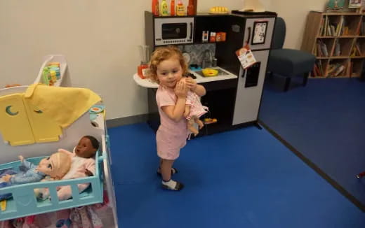 a baby girl standing in a room