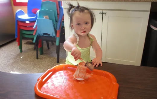 a little girl eating a piece of meat