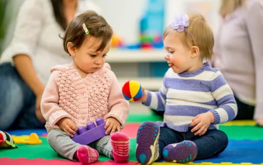 a couple of young girls sitting on the floor