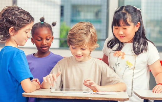 a group of children looking at a tablet