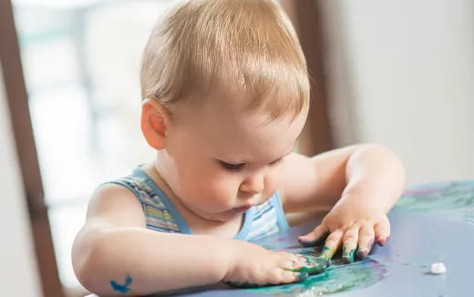 a baby playing with water