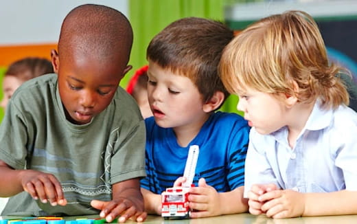 a group of children looking at a book