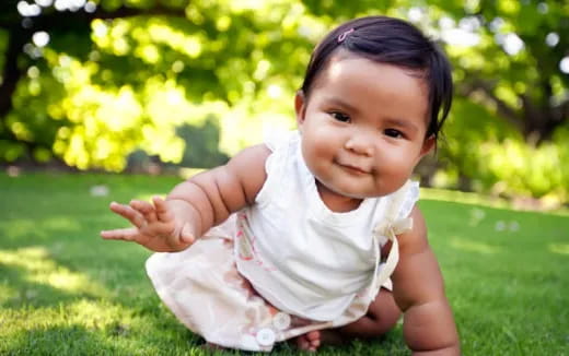 a baby sitting on grass