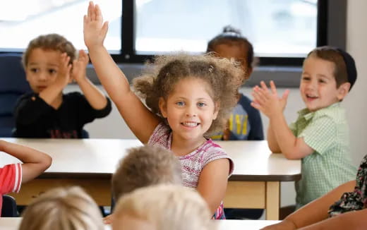a group of children raising their hands