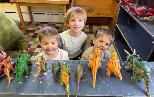 a group of kids sitting in a pool with toys